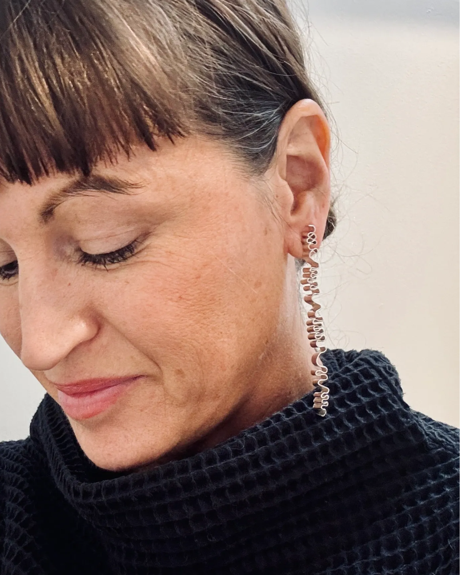Woman wearing a black sweater with a neutral background