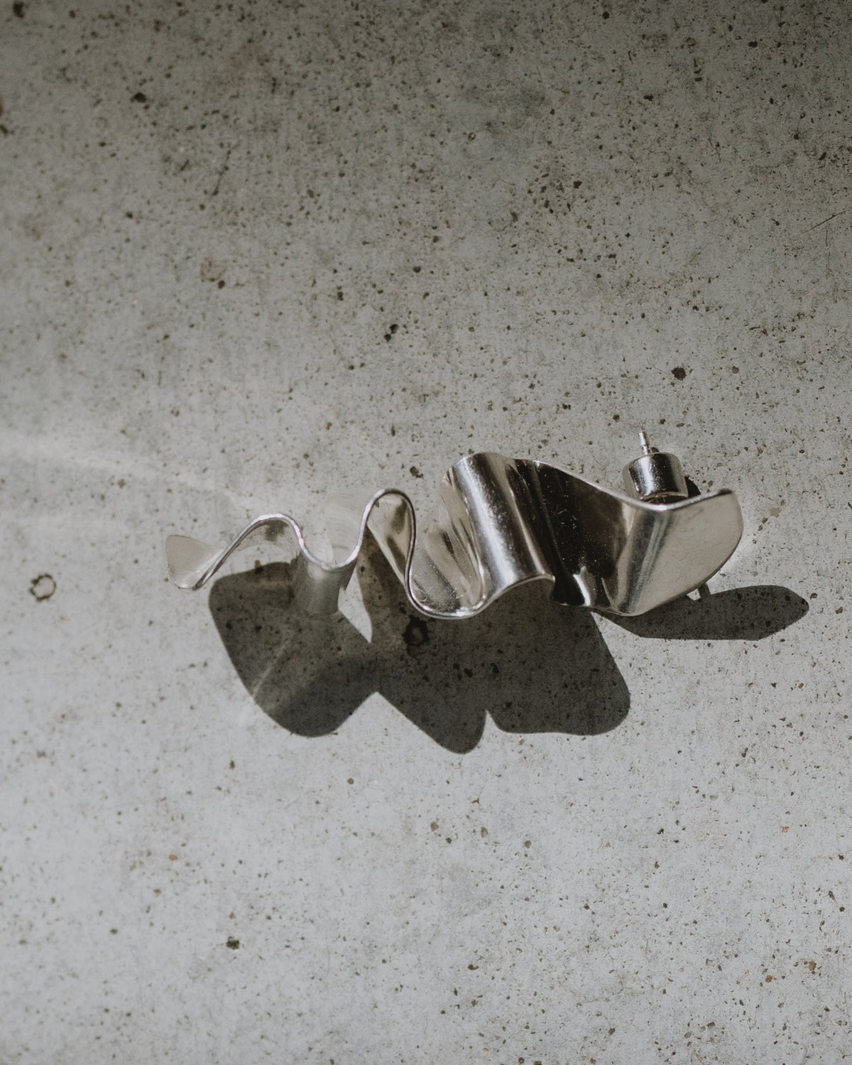 silver sculptural objects on concrete floor